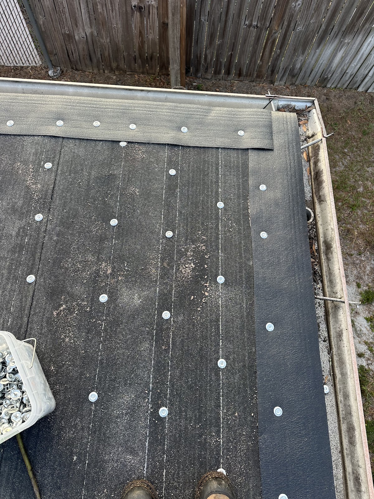 Close view of roof repair fasteners and shingles